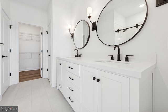 19740 Spinnaker Ct, Georgetown, DE 19947 - full bathroom featuring double vanity, tiled shower, and a walk in closet