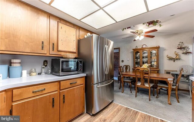 3324 Golf Course Rd, Allentown, PA 18104 - kitchen with stainless steel appliances, a ceiling fan, light countertops, light wood-style floors, and brown cabinetry