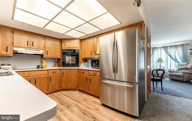 3324 Golf Course Rd, Allentown, PA 18104 - kitchen featuring black appliances, under cabinet range hood, light countertops, brown cabinets, and light wood-style flooring