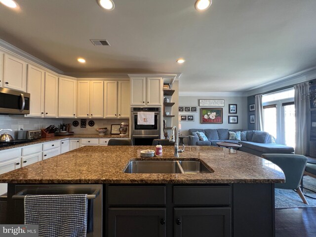 13755 Tides St, Woodbridge, VA 22191 - kitchen featuring appliances with stainless steel finishes, a center island with sink, crown molding, dark stone countertops, and open floor plan