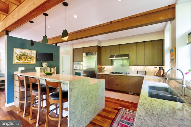 4305 Blagden Ave NW, Washington, DC 20011 - kitchen with appliances with stainless steel finishes, dark wood-type flooring, under cabinet range hood, a center island, and recessed lighting