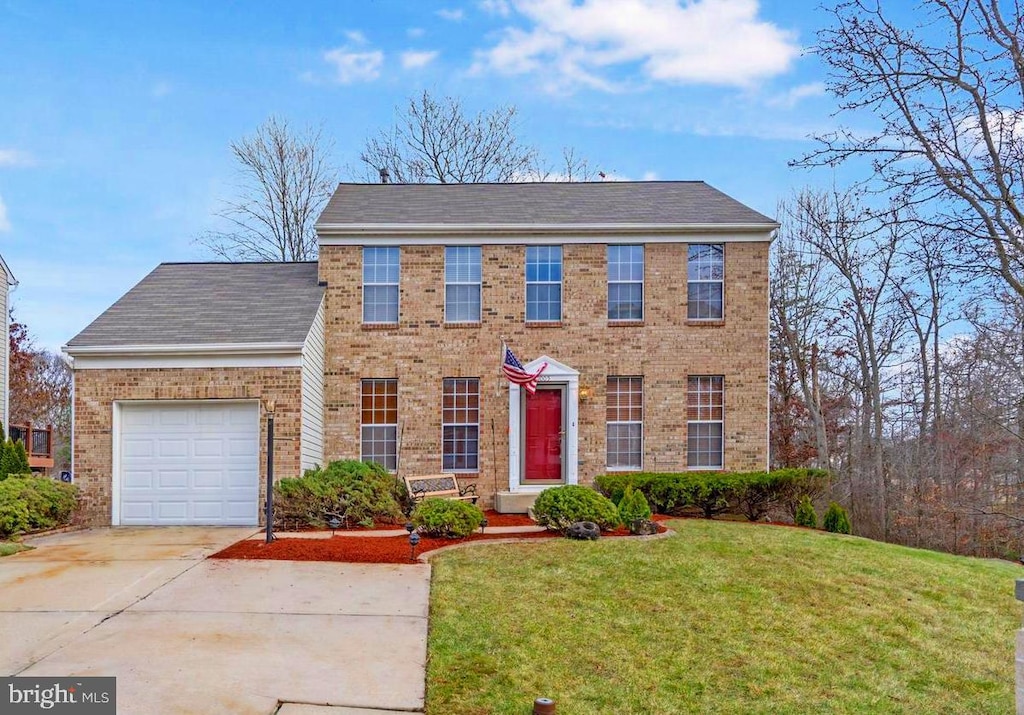 1005 Mariner Rd, Joppa, MD 21085 - colonial home featuring brick siding, a garage, driveway, a front yard, and roof with shingles