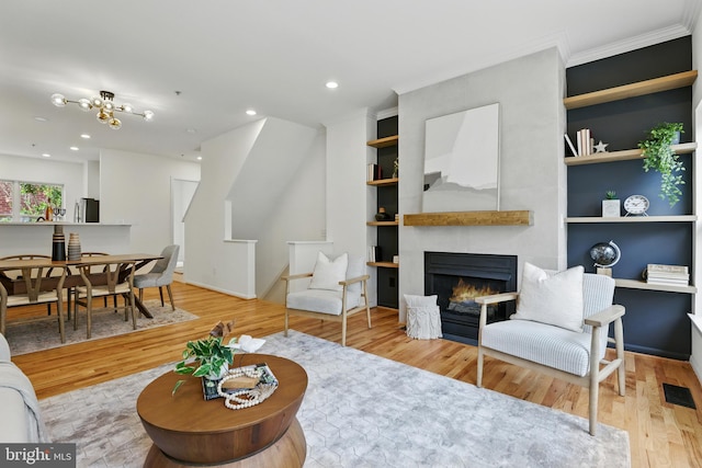 2127 12th Pl NW, Washington, DC 20009 - living room with crown molding, wood finished floors, a warm lit fireplace, built in shelves, and recessed lighting