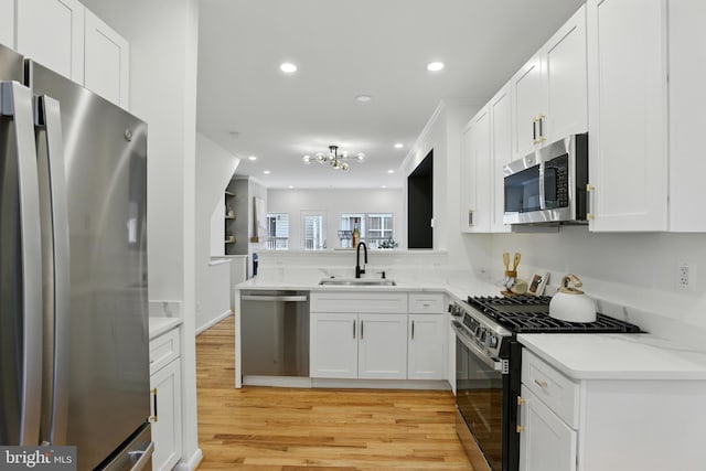 2127 12th Pl NW, Washington, DC 20009 - kitchen with appliances with stainless steel finishes, light wood-type flooring, recessed lighting, white cabinets, and a peninsula