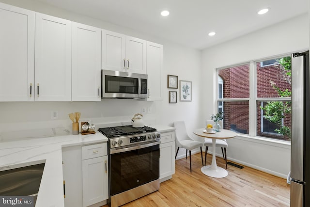 2127 12th Pl NW, Washington, DC 20009 - kitchen featuring stainless steel appliances, white cabinetry, light stone countertops, light wood finished floors, and recessed lighting