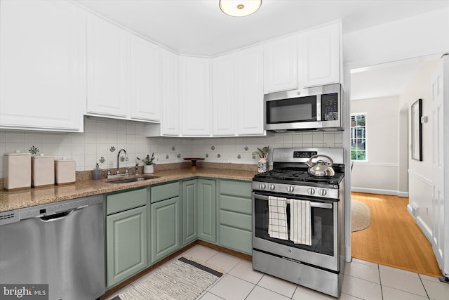 505 Dartmouth Ave, Silver Spring, MD 20910 - kitchen with stainless steel appliances, white cabinets, tasteful backsplash, and light tile patterned flooring