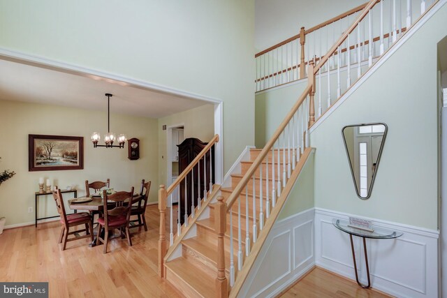 213 Casper Way, Middletown, DE 19709 - staircase with wood finished floors, a chandelier, wainscoting, and a high ceiling