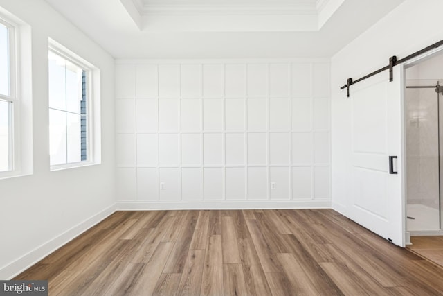 19712 Crows Nest Ct, Georgetown, DE 19947 - interior space featuring a barn door, wood finished floors, a tray ceiling, and ornamental molding