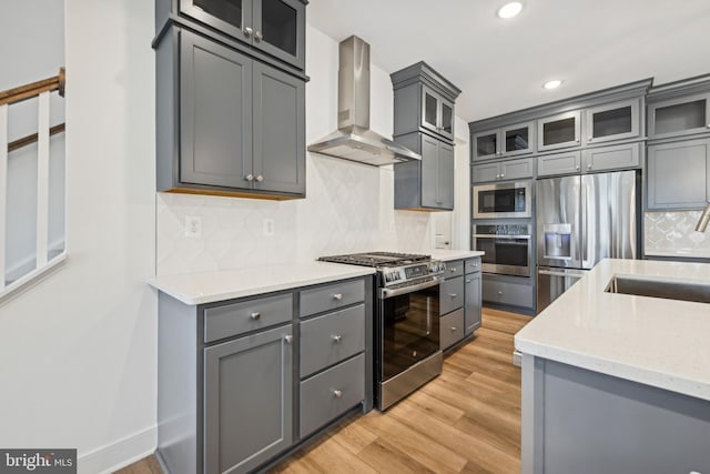 19712 Crows Nest Ct, Georgetown, DE 19947 - kitchen featuring appliances with stainless steel finishes, wall chimney range hood, gray cabinetry, a sink, and recessed lighting