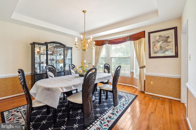 2363 Ashford Dr, Waldorf, MD 20603 - dining space featuring a tray ceiling, a chandelier, and light wood-style flooring