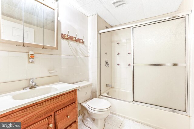 2363 Ashford Dr, Waldorf, MD 20603 - bathroom with vanity, tile patterned flooring, combined bath / shower with glass door, and tile walls