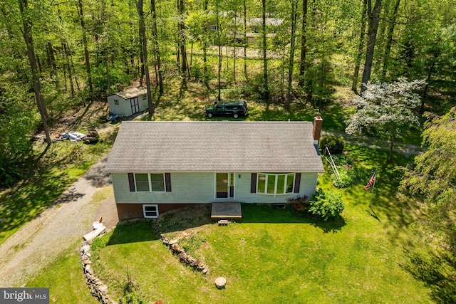 6 Camelia Ln, Holtwood, PA 17532 - view of front facade featuring a shingled roof, a chimney, a storage shed, driveway, and a front lawn