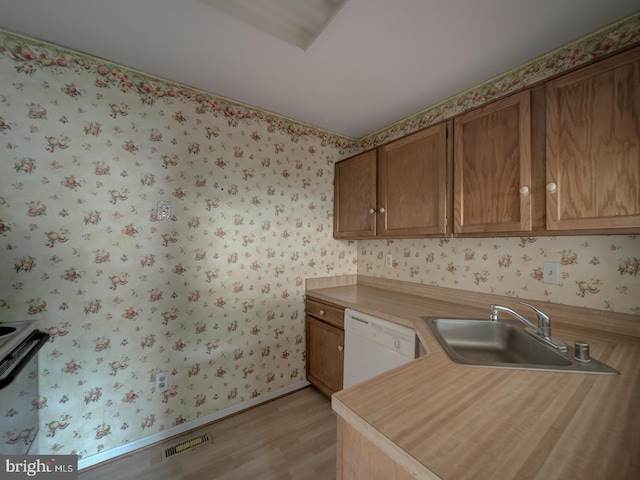 15069 Maple Glen Ct, Dumfries, VA 22025 - kitchen with dishwasher, light countertops, wallpapered walls, light wood-style floors, and brown cabinets