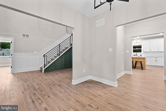2725 S Sunset Ave, Williamstown, NJ 08094 - unfurnished living room with stairs, light wood-type flooring, a ceiling fan, and a high ceiling