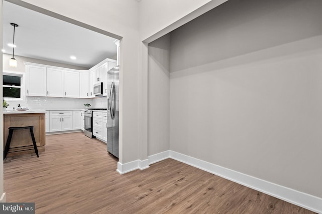 2725 S Sunset Ave, Williamstown, NJ 08094 - kitchen with appliances with stainless steel finishes, light wood-style flooring, white cabinetry, tasteful backsplash, and recessed lighting