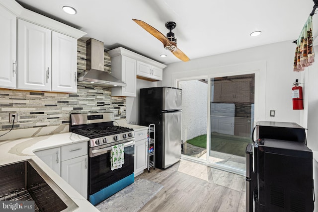 1228 S 22nd St, Philadelphia, PA 19146 - kitchen with appliances with stainless steel finishes, wall chimney range hood, a ceiling fan, white cabinets, and recessed lighting