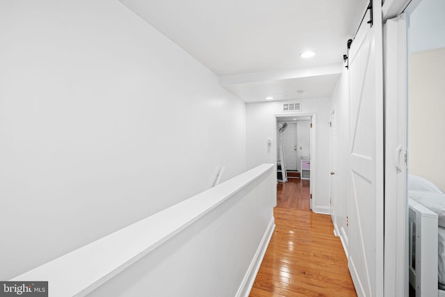 1228 S 22nd St, Philadelphia, PA 19146 - corridor with light wood-style flooring, a barn door, recessed lighting, and washer / dryer