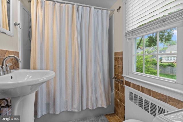 440 E Magnolia Dr, Morrisville, PA 19067 - bathroom featuring tile walls, radiator heating unit, shower / bath combo with shower curtain, and a wainscoted wall