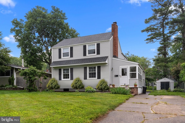 440 E Magnolia Dr, Morrisville, PA 19067 - view of front of house with a shingled roof, a chimney, a front yard, and an outbuilding