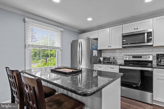 440 E Magnolia Dr, Morrisville, PA 19067 - kitchen with appliances with stainless steel finishes, crown molding, white cabinetry, dark stone counters, and recessed lighting