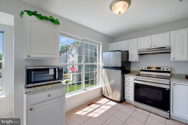 2222 Commissary Cir Unit 198, Odenton, MD 21113 - kitchen with under cabinet range hood, stainless steel appliances, white cabinetry, light tile patterned floors, and light stone counters