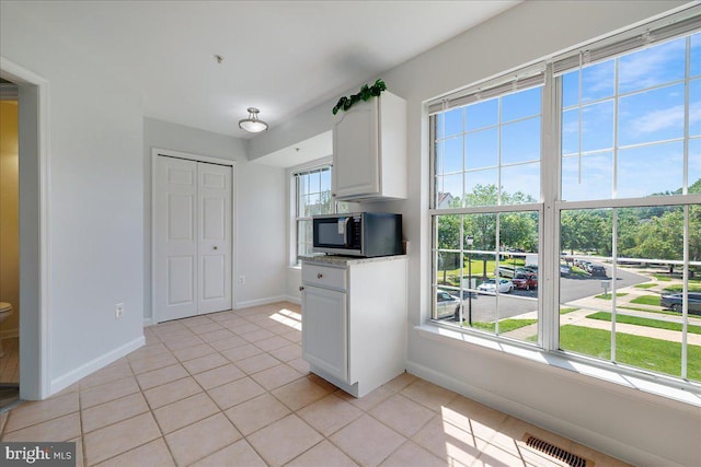 2222 Commissary Cir Unit 198, Odenton, MD 21113 - kitchen with stainless steel microwave, light tile patterned flooring, and white cabinetry