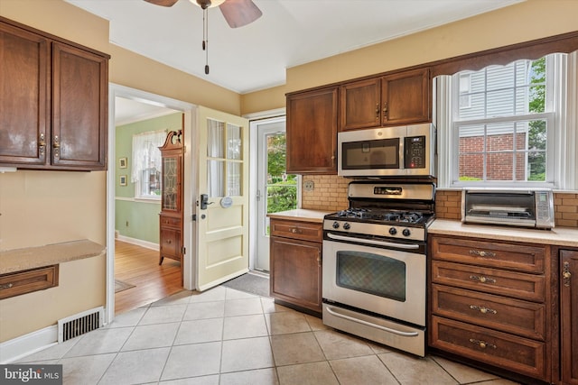 515 Marks Rd, Oreland, PA 19075 - kitchen with appliances with stainless steel finishes, backsplash, light countertops, a ceiling fan, and light tile patterned floors