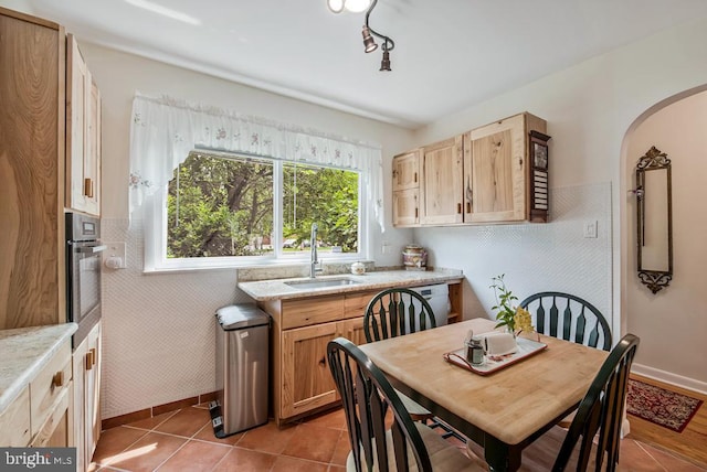 1312 Cedar Park Rd, Annapolis, MD 21401 - kitchen with arched walkways, stainless steel oven, light brown cabinetry, and light tile patterned flooring