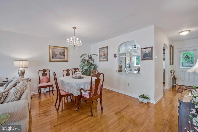 1312 Cedar Park Rd, Annapolis, MD 21401 - dining space featuring arched walkways, a chandelier, and light wood-type flooring