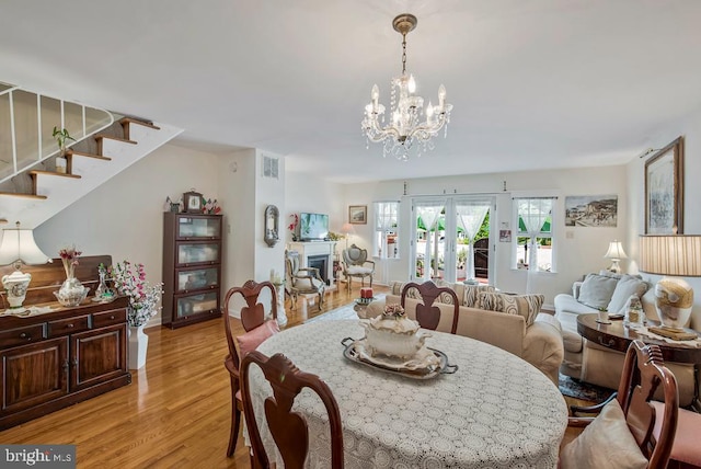 1312 Cedar Park Rd, Annapolis, MD 21401 - dining room featuring light wood-style flooring, stairway, and a chandelier