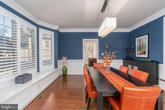 6139 Sligo Mill Rd NE, Washington, DC 20011 - dining space with wood finished floors, crown molding, a wainscoted wall, and a chandelier