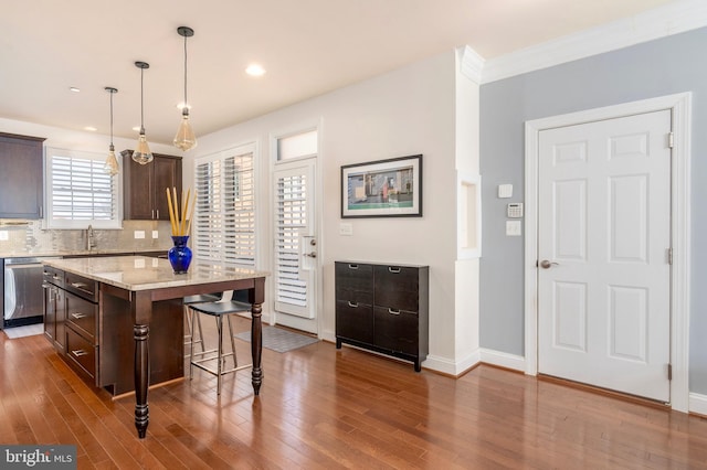 6139 Sligo Mill Rd NE, Washington, DC 20011 - kitchen featuring dishwasher, dark brown cabinets, a kitchen bar, wood finished floors, and a kitchen island