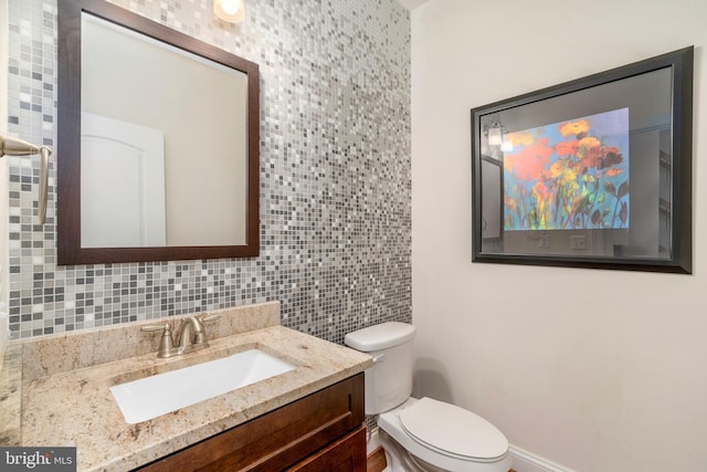6139 Sligo Mill Rd NE, Washington, DC 20011 - bathroom featuring toilet, vanity, tile walls, backsplash, and baseboards