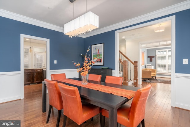 6139 Sligo Mill Rd NE, Washington, DC 20011 - dining room featuring stairway, ornamental molding, wood-type flooring, wainscoting, and a chandelier