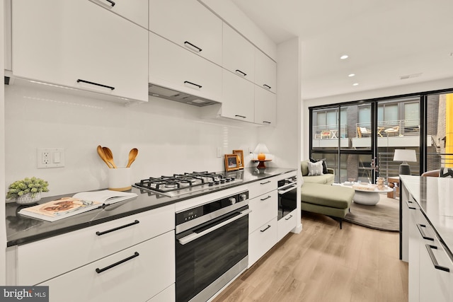 1500 Harry Thomas Way NE Unit 504, Washington, DC 20002 - kitchen featuring stainless steel appliances, white cabinets, light wood finished floors, dark countertops, and recessed lighting