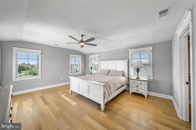 1005 Dune Dr, Avalon, NJ 08202 - bedroom with vaulted ceiling, light wood finished floors, multiple windows, and a ceiling fan