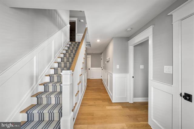 1005 Dune Dr, Avalon, NJ 08202 - staircase featuring recessed lighting, wood finished floors, a wainscoted wall, and a decorative wall
