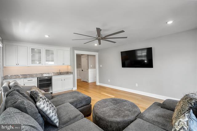 1005 Dune Dr, Avalon, NJ 08202 - living room with beverage cooler, bar with sink, light wood-style flooring, a ceiling fan, and recessed lighting
