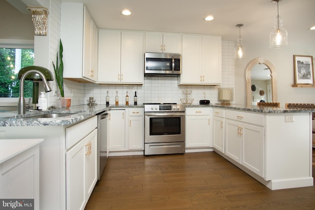 9007 Millers Island Blvd, Baltimore, MD 21219 - kitchen featuring appliances with stainless steel finishes, a peninsula, white cabinets, light stone countertops, and recessed lighting