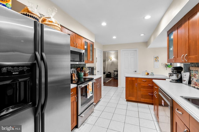 14519 Keeneland Cir, North Potomac, MD 20878 - kitchen with stainless steel appliances, light tile patterned floors, backsplash, brown cabinetry, and recessed lighting