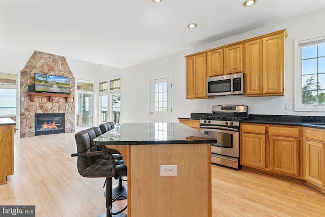40461 Old Breton Beach Rd, Leonardtown, MD 20650 - kitchen featuring appliances with stainless steel finishes, open floor plan, a kitchen bar, light wood finished floors, and a kitchen island