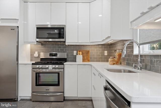 1002 S Colorado St, Philadelphia, PA 19146 - kitchen featuring appliances with stainless steel finishes, white cabinets, light countertops, and decorative backsplash