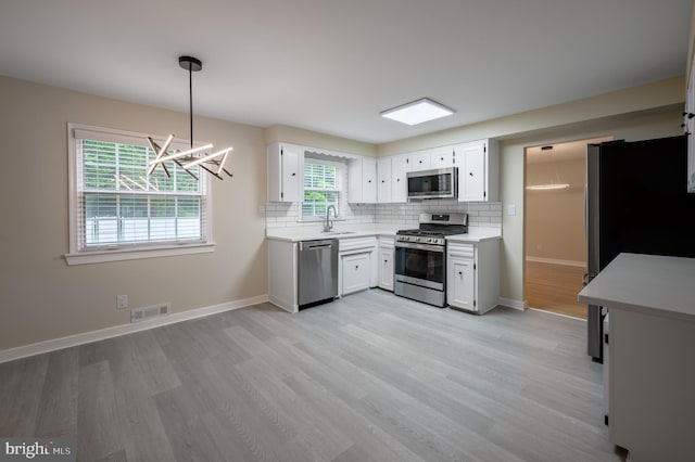 27 Kevin Way, Marlton, NJ 08053 - kitchen featuring appliances with stainless steel finishes, light wood-style floors, light countertops, backsplash, and white cabinetry