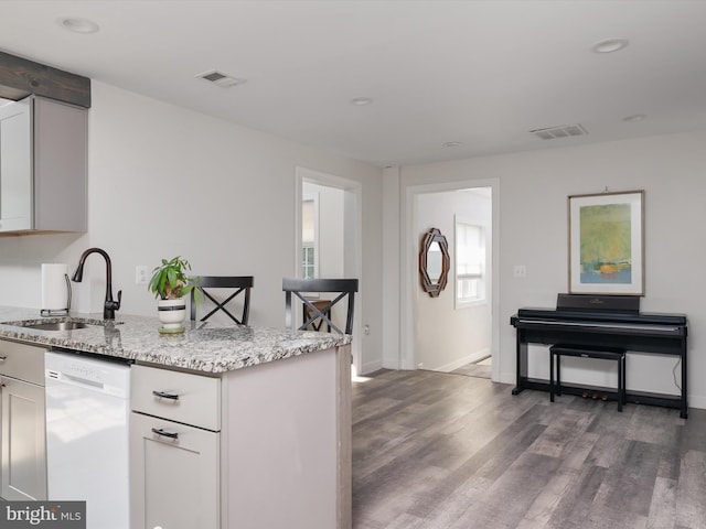 7802 Gary Ln, Severn, MD 21144 - kitchen with white dishwasher, wood finished floors, light stone countertops, a peninsula, and white cabinetry