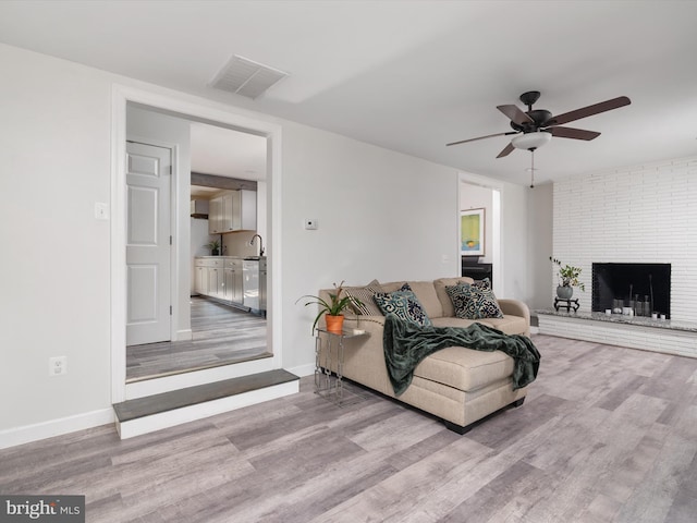 7802 Gary Ln, Severn, MD 21144 - living room with wood finished floors, ceiling fan, and a brick fireplace