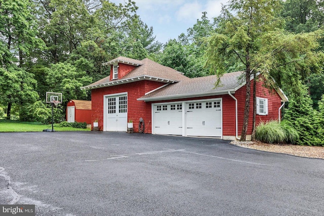 2165 Broadway, Hanover, PA 17331 - view of side of home with roof with shingles, an attached garage, a shed, asphalt driveway, and view of wooded area