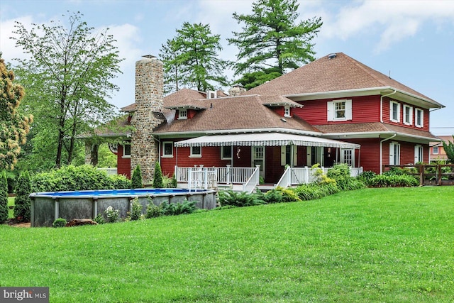 2165 Broadway, Hanover, PA 17331 - rear view of house with a chimney, an outdoor pool, roof with shingles, and a lawn