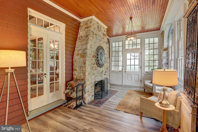 2165 Broadway, Hanover, PA 17331 - living room featuring wood ceiling, crown molding, wood finished floors, a stone fireplace, and wooden walls