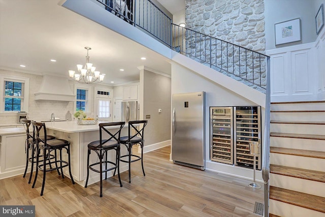 2165 Broadway, Hanover, PA 17331 - kitchen featuring premium range hood, freestanding refrigerator, a kitchen breakfast bar, healthy amount of natural light, and crown molding