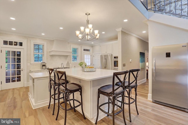 2165 Broadway, Hanover, PA 17331 - kitchen with appliances with stainless steel finishes, custom exhaust hood, ornamental molding, a chandelier, and light countertops